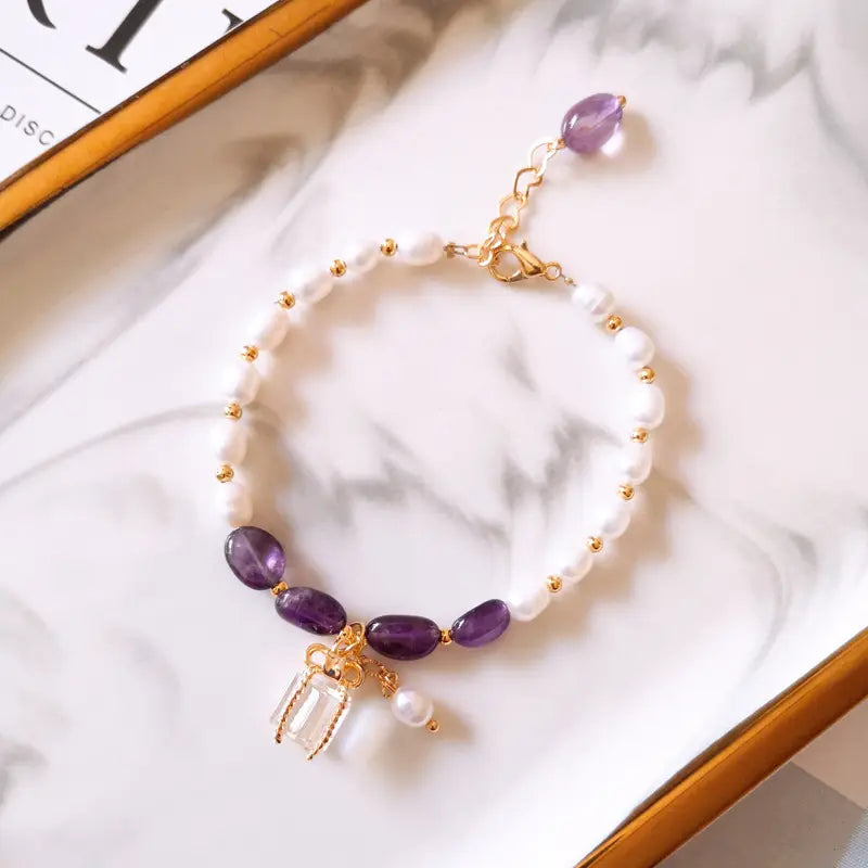 Aksesuaras su violetiniais akmenimis ir perlais auksu